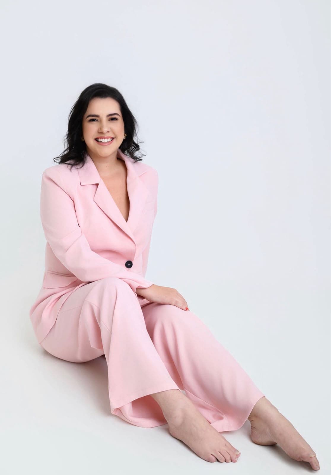Laís Douetts sorrindo, sentada